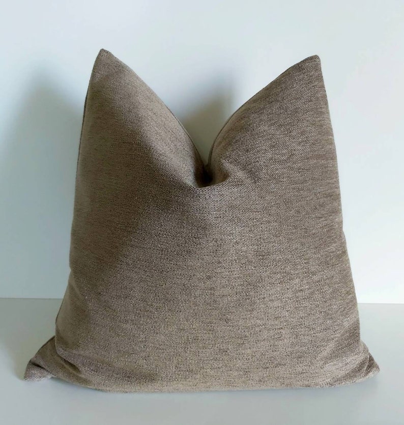 May include: A brown square pillow with a textured fabric.