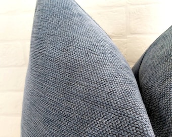 May include: Two blue throw pillows with a textured fabric. The pillows are arranged in a V-shape.