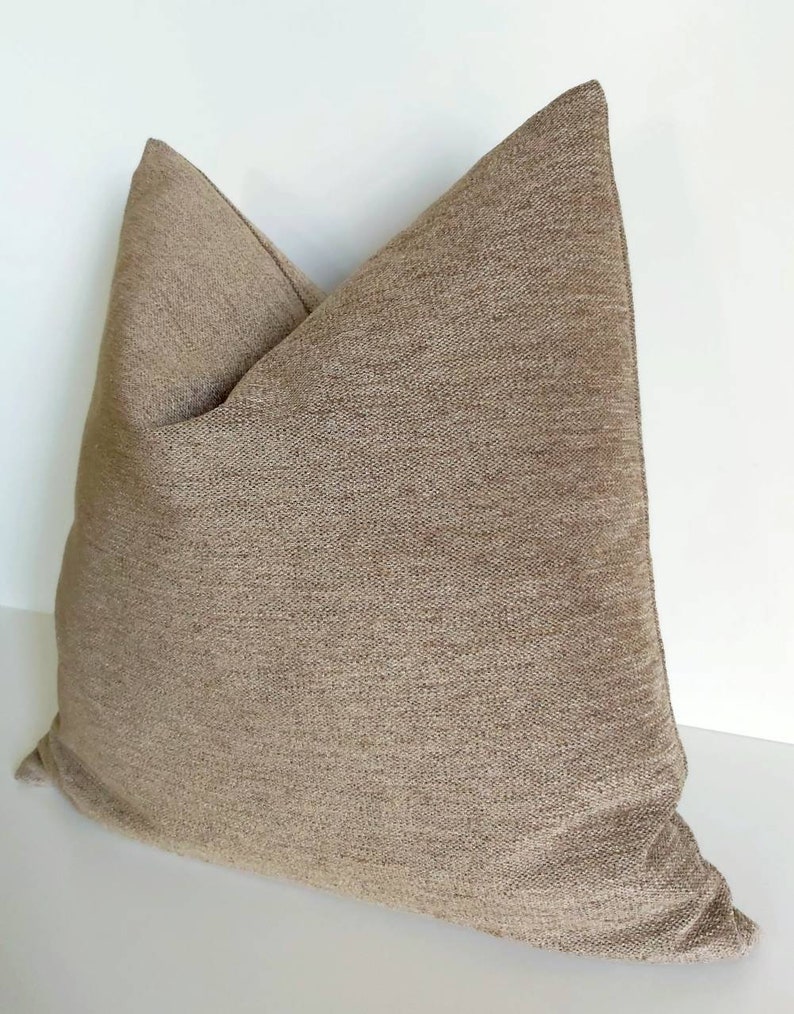 May include: A brown square throw pillow with a textured fabric.