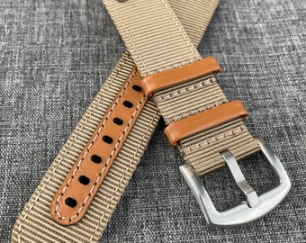 May include: Two beige nylon watch straps with brown leather lining and silver buckle. The straps have stitching along the edges and two silver eyelets.