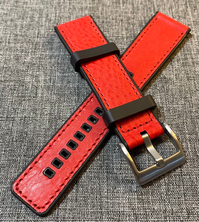 Op de afbeelding: Rood leren horlogeband met zwarte stiksels en een zwarte gesp. Het band heeft een gestructureerd oppervlak en is ontworpen voor een horloge met een lugbreedte van 20 mm.