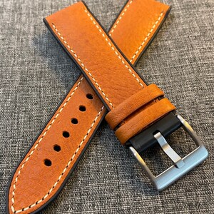 May include: A brown leather watch strap with white stitching and a silver buckle. The strap is designed for a watch with a 20mm lug width.