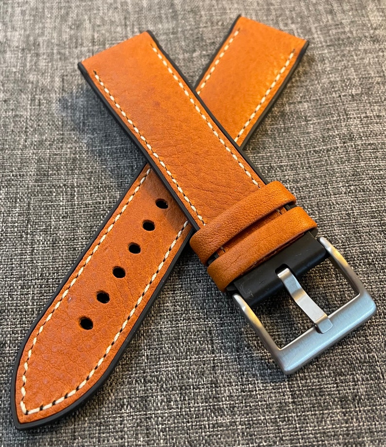 May include: A brown leather watch strap with white stitching and a silver buckle. The strap is designed for a watch with a 20mm lug width.
