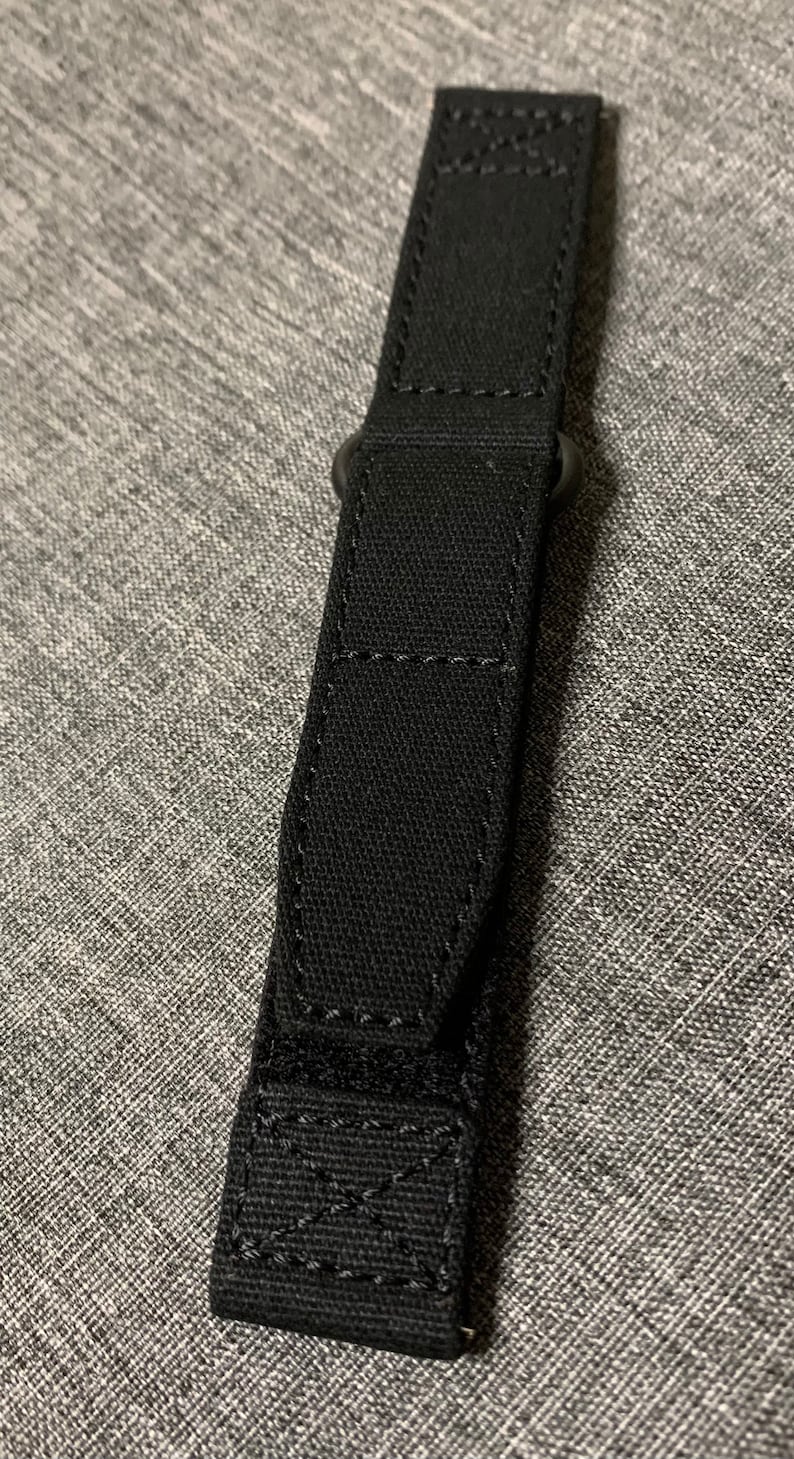 May include: Black watch strap with a stitched design and a buckle.