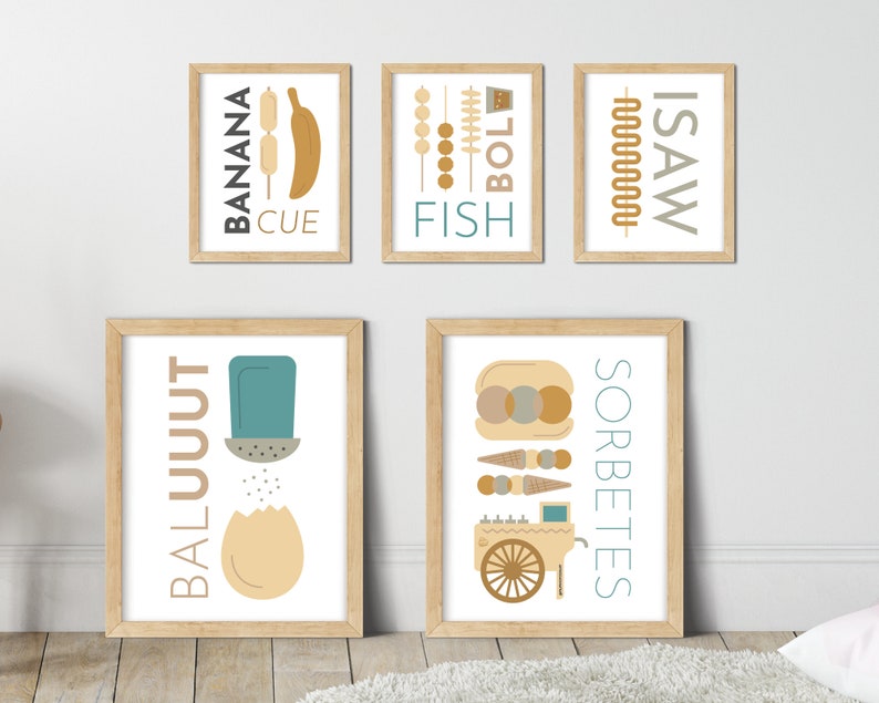 May include: Five framed prints with illustrations and text. The prints are in a light wood frame with a white mat. The prints are hung on a white wall. The prints feature the words "BALUUUT", "SORBETES", "ISAW", "FISH", and "BANANA CUE".