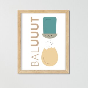 May include: A framed print with a minimalist design featuring a blue salt shaker pouring salt onto a yellow egg. The text "BALUUUT" is written vertically on the left side of the print.