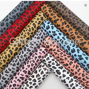 Peut inclure: Une collection de tissus roulés avec un motif léopard de différentes couleurs. Les couleurs incluent le gris, le rouge, le jaune, le bleu clair, l'orange, le marron, le rose et le blanc. Le texte "Cute Shine" est visible.