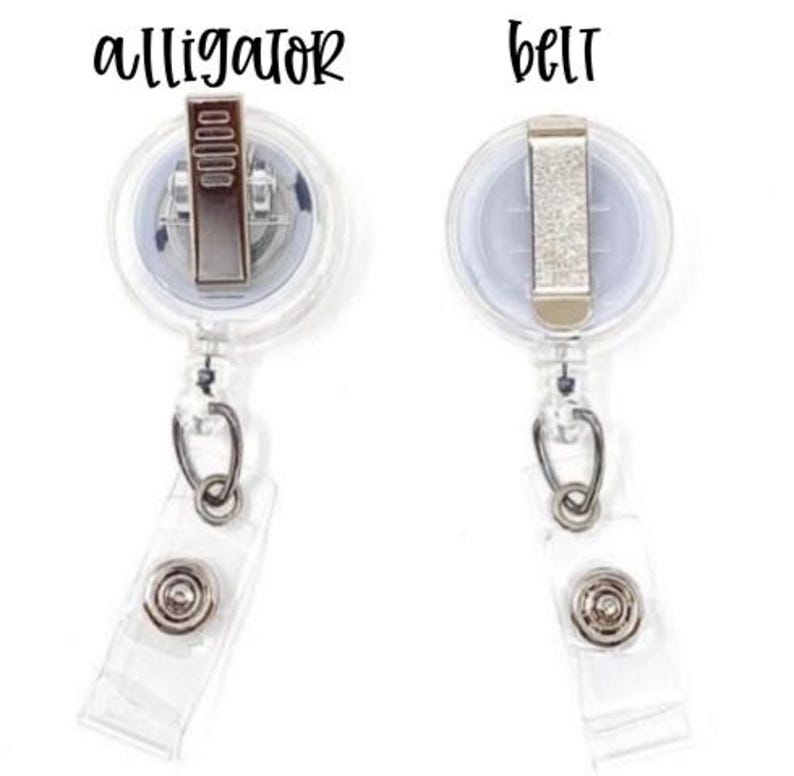 Pu&ograve; includere: Due porta badge retrattili trasparenti con clip in metallo. Uno &egrave; etichettato "alligator" e l'altro "belt" in corsivo nero. Ognuno ha un cinturino in plastica trasparente con chiusura a scatto e un anello in metallo color argento.