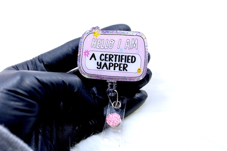 May include: Pink glitter badge holder with a pink and white rectangle that says "Hello I am a certified yapper".