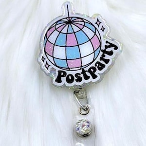 May include: A clear acrylic badge reel featuring a glittery disco ball graphic with pink and blue panels. The text "Postparty" is printed in bold black letters below the disco ball, accompanied by small star icons on a shimmering, translucent base.