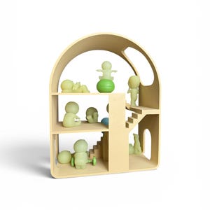 May include: A light beige wooden dollhouse with multiple levels and a curved roof. The dollhouse is furnished with small, green-tinted figurines in various poses. Some figurines are standing, sitting, or lying down. A green ball and a green toy with wheels are also present.