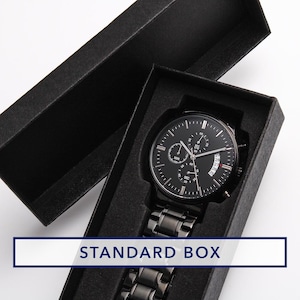 May include: A black wristwatch with a black metal band is displayed inside a black box. The watch face has multiple sub-dials and a date display. The box has the words "STANDARD BOX" in a white rectangle.
