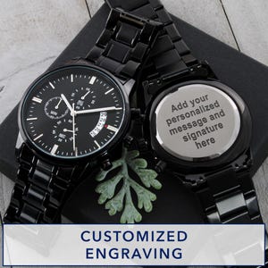 May include: Two black chronograph watches with matching black metal bands. One watch face displays the time, date, and sub-dials. The other watch has a silver back with the text "Add your personalized message and signature here". The image also includes the text "CUSTOMIZED ENGRAVING".