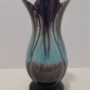 May include: A blue and brown ceramic vase with a flared top and a rounded base. The vase has a unique, marbled glaze.