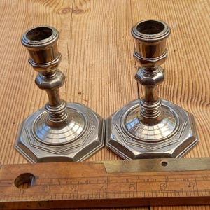 Puede incluir: Dos candelabros antiguos de latón con bases octogonales y un diseño acanalado. Los candelabros miden aproximadamente 12,7 cm de alto.