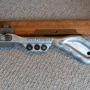 May include: A silver metal tool with a handle and a mechanism for crimping. The tool is labeled "MOTA PRODUCTS".