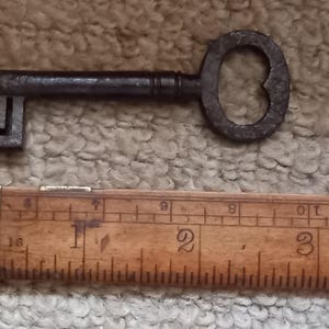 Símbolo de amor antiguo, una llave entregada a una novia el día de su boda, un regalo de su futuro esposo, un corazón de amor en el moño y las iniciales en la hoja.