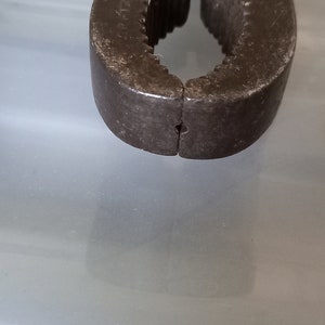以下が含まれることがあります： さび付いた金属製のナッツクラッカーの顎のクローズアップ。顎は閉じられており、摩耗の兆候が見られます。