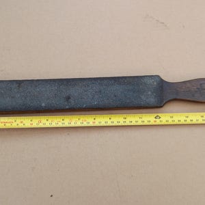 Puede incluir: Un acero de afilar vintage de madera y gris, que mide 33 cm de largo, con un mango de madera. El acero se utiliza para afilar cuchillos.