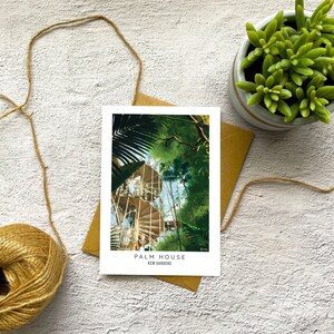 Peut inclure: Une carte postale repr&eacute;sentant une peinture de la Palm House des Jardins de Kew. L'image montre un escalier en colima&ccedil;on &agrave; l'int&eacute;rieur d'une structure en verre entour&eacute;e d'une v&eacute;g&eacute;tation luxuriante.