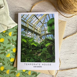 Peut inclure: Une carte blanche avec une photo de la Serre temp&eacute;r&eacute;e des Jardins de Kew. La photo montre une grande serre en verre avec des plantes vertes luxuriantes &agrave; l'int&eacute;rieur. Le texte "TEMPERATE HOUSE" et "KEW GARDENS" est imprim&eacute; sur la carte.