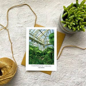 Peut inclure: Une carte postale repr&eacute;sentant une peinture de la Temperate House des Jardins de Kew. La peinture montre une grande serre en verre remplie de plantes vertes luxuriantes.