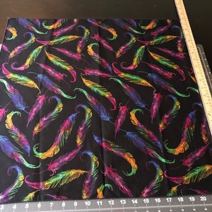 May include: Black fabric with a repeating pattern of colorful feathers. The feathers are outlined in gold and have a shimmery finish.