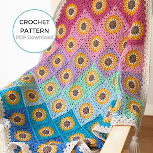 May include: A crochet blanket featuring a pattern of sunflower motifs in yellow and brown, arranged in a gradient of pink, purple, mint, and blue squares. A cream-colored border with tassels edges the blanket. Text reads CROCHET PATTERN PDF Download.