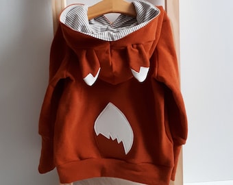 Hoodie with fox ears and foxtail for children made of soft French terry in rust red and matching ringed lining in the hood