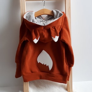 Hoodie with fox ears and fox tail for children made of soft French terry in rust red and matching striped lining in the hood