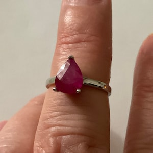 Peut inclure: Une bague en argent avec une pierre précieuse en rubis de forme poire.