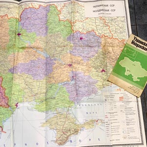 May include: A vintage map of the Ukrainian SSR and Moldavian SSR, with a scale of 1:1,500,000. The map is folded and shows the borders of the two republics, as well as major cities and rivers. A smaller map of the region is also visible in the bottom right corner.