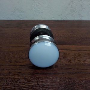 May include: A silver and black dumbbell with a white rubber end cap.