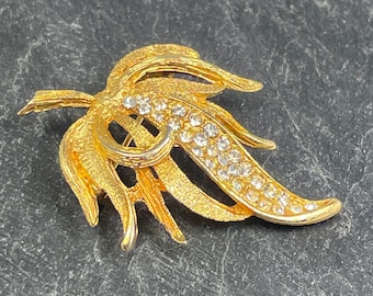 A wonderful little vintage leaf brooch made in gold tone metal and set with little clear rhinestones in the middle