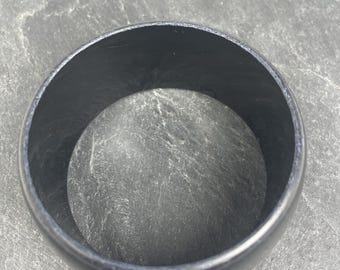 A wide vintage black plastic bangle, possibly gothic, punky, rocky