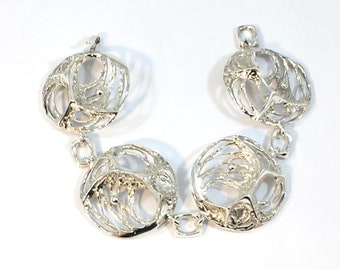 May include: Silver bracelet with four round, openwork links. Each link has a textured, organic design.