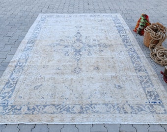 May include: A vintage rug with a faded blue and cream color scheme. The rug has a central medallion design and a border with floral motifs.