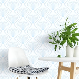 Light blue art deco wallpaper on a wall behind a chair and a table with a plant on it.