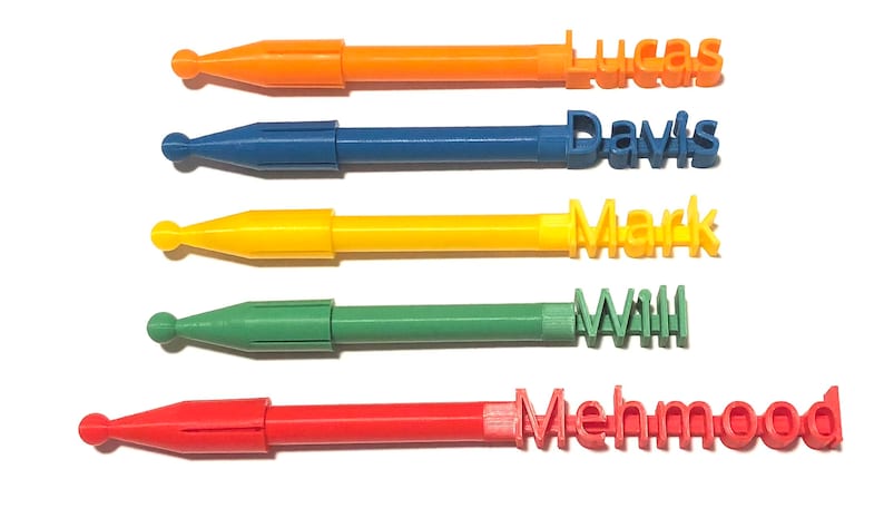 Pu&ograve; includere: Cinque penne colorate personalizzate con nomi stampati sulle estremit&agrave;. Le penne sono arancioni, blu, gialle, verdi e rosse.