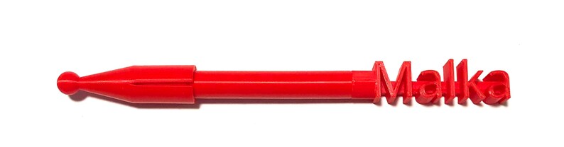 Pu&ograve; includere: Una penna di plastica rossa con la parola "Malka" stampata sul lato.