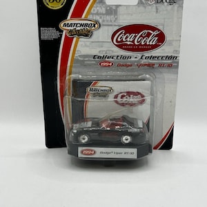 Puede incluir: Un coche de juguete Matchbox Collectibles 1994 Dodge Viper RT/10 en un paquete de Coca-Cola. El coche negro tiene detalles rojos y el logotipo de Coca-Cola. El embalaje incluye los logotipos de Matchbox y Dodge.