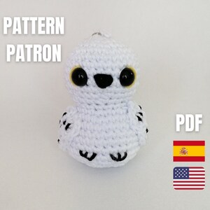 May include: Crochet pattern for a white owl with black eyes and yellow pupils. The pattern is available in PDF format and includes both English and Spanish instructions. The pattern is titled "PATTERN PATRON".