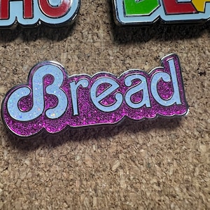 Daily Bread pink glitter Hard Enamel pin by @musicfestivalstickers + @PatchAndStash. 1.5 inches LE 111
