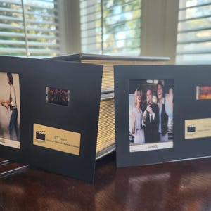 May include: Two black framed film memorabilia, each with film stills and a 35mm film strip. The frames display images from the movie, with a gold plaque that reads "Original Lithograph Special Edition".