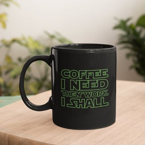 May include: Black coffee mug with green text that reads "Coffee I Need Then Work I Shall".