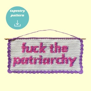 Può includere: Arazzo da parete all'uncinetto con la frase "fuck the patriarchy" in lettere rosa su sfondo bianco. Lo striscione ha un bordo smerlato viola ed è sospeso da un tassello di legno. Un cerchio turchese con le parole "tapestry pattern" si trova nell'angolo in alto a sinistra.