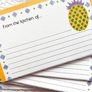 Könnte beinhalten: Rezeptkarten mit orangefarbenem Rand und einer Ananas-Illustration. Die Karten tragen den Text "From the kitchen of..." und sind zum Schreiben von Rezepten liniert. Das Design umfasst blaue Diamanten und grüne Punkte.