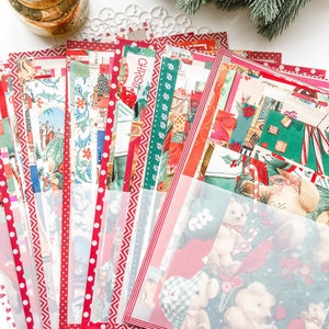 May include: A stack of vintage Christmas cards with red, green, and white designs. The cards feature a variety of holiday themes, including Santa Claus, reindeer, and snowmen. The cards are arranged in a fan shape, with the top card showing a red and white polka dot pattern.