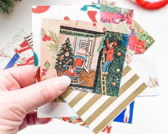 May include: A collection of small, square paper cards featuring vintage-style Christmas illustrations, including a person on a ladder decorating a tree, a rocking chair with a gift, holly berries, and gold-and-white diagonal stripes.
