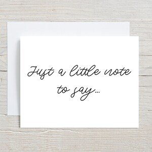 May include: A white card with black text that reads "Just a little note to say..."
